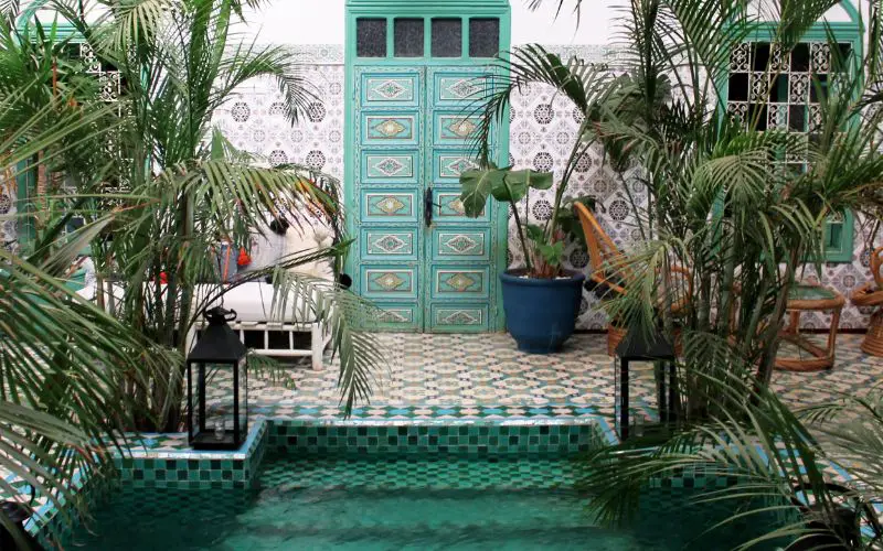 L'entrée d'une chambre face à la piscine dans un riad à Marrakech 