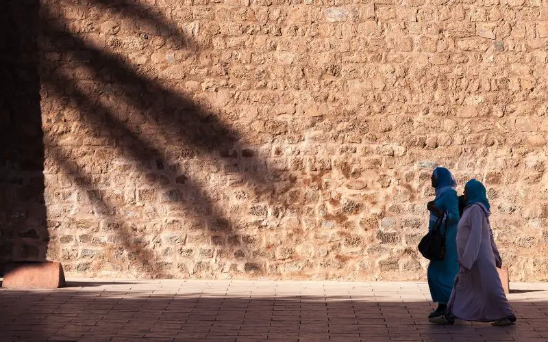 Des femmes marocaines se promènent à l'ombre lors d'un après-midi de chaleur à Marrakech
